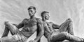 Sexy torso attractive body. Denim pants emphasize masculinity sexuality. Men twins brothers muscular guys sit relax sky Royalty Free Stock Photo