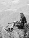 Sexy warrior. Woman attractive long hair pretty face hold rifle for hunting. Aiming concept. Amazon girl sit on cliff