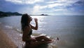 woman in bikini sits on sea at the beach and