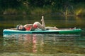 Sexy woman with blue braids posing on an inflatable boat on river