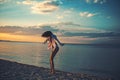 woman dance on Caribbean sea in Bahamas at sunset. Girl relax on pebble beach fashion swimsuit. Summer vacation and Royalty Free Stock Photo