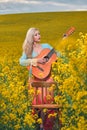 sexy woman in the field with a guitar. concept freedom, inspiration, relaxation. Royalty Free Stock Photo