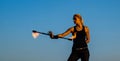 Sexy woman fire performer manipulate flaming baton evening blue sky outdoors, twirling Royalty Free Stock Photo