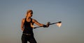 Sexy woman fire performer manipulate flaming baton evening blue sky outdoors, twirling Royalty Free Stock Photo