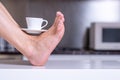 Sexy woman foot legs with cup coffee, close up.