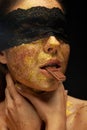 Sexy woman with gold makeup and lace mask, eating chocolate Royalty Free Stock Photo