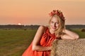 woman on hay stack on sunset.