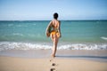 Sexy woman holding fresh pineapple. Buttocks of girl in bikini with fruit pineapple on beach background, summer vacation Royalty Free Stock Photo