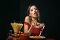 Sexy woman in italian style eating spaghetti with her hands. Sexy kitchen. Woman hold plate with spaghetti. Woman cooked