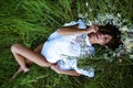 Sexy woman lying on grass. Summer beauty sexy woman outdoor portrait. Young beautiful woman relaxing in the field with Royalty Free Stock Photo