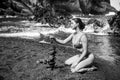 Sexy woman making stack of pebbles stone against sea background for spa, balance, meditation and zen theme. Life balance Royalty Free Stock Photo