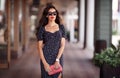 Sexy woman portrait, Caucasian beautiful trend female posing near window of clothing store, holding handbag, wearing dress and Royalty Free Stock Photo