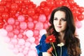 brunette woman with red heart balloons and flowers