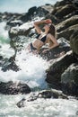 Sexy woman on rocks stone beach. Beautiful womans body in sexy bikini on beach. Sensual girl in bikini on sea. Outdoor Royalty Free Stock Photo