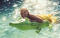 Sexy woman on sea with inflatable mattress. Fashion crocodile leather and girl in water. Summer vacation and travel to Royalty Free Stock Photo