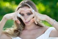 Sexy woman with sensual look with love heart finger in spring park. Beauty portrait of beautiful female model outside