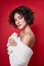 woman with short hair cut in white sweater on red background. Perfect girl with wet tousled dark hair and bright makeup, Royalty Free Stock Photo