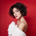 woman with short hair cut in white sweater on red background. Perfect girl with wet tousled dark hair and bright makeup, Royalty Free Stock Photo