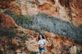 Sexy woman in short jeans and an open shirt showing a fit belly standing with an cliff behind Royalty Free Stock Photo