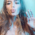 woman in shower. Attractive young naked woman under water drops on blue background Royalty Free Stock Photo