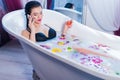 woman speaking on the phone while taking a bath