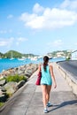 woman walk along sea in st.thomas, british virgin island. Woman in top and shorts on sea side promenade on sunny day, back vi Royalty Free Stock Photo