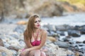 woman wear pink bikini sitting on sea rocks Royalty Free Stock Photo