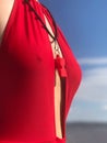 woman wearing red lifeguard swimsuit with red whistle posting on the beach