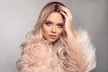 Sexy woman wears in pink fur coat. Ombre blond hairstyle. Beauty fashion blonde portrait. Beautiful girl model with makeup, long Royalty Free Stock Photo