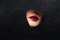 Sexy women`s lips with red lipstick in a heart-shaped cutout. Royalty Free Stock Photo