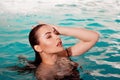 Sexy young beauty swims in the pool alone. Spa and relaxation. Royalty Free Stock Photo