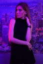 young beauty woman posing over night city dramatic pink neon and city background