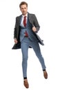 Sexy young businessman in blue suit jumping and pulling grey coat Royalty Free Stock Photo
