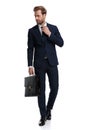 Sexy young businessman in navy blue suit fixing tie Royalty Free Stock Photo