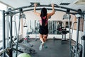 Sexy young fitness girl pulls up in the gym. Brunette fitness woman in black sport wear Royalty Free Stock Photo