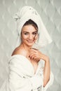 young girl with dark hair, big eyes and dark eyebrows wearing white bath robe whith towel on her head. Royalty Free Stock Photo