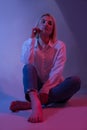 Seductive Elegance: Sensual Portrait of a Blonde Model in Colorful Studio Lights