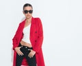 sexy young girl with sunglasses in red coat holding black pants Royalty Free Stock Photo