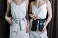 Sexy young girls in white dresses. Leather jewelry, designer leather handbags. Attached to the belt.