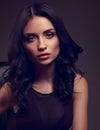 young makeup model in brown dress and curly hairstyle posin Royalty Free Stock Photo