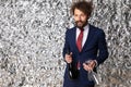 Sexy young man in elegant suit holding wine bottle and glasses Royalty Free Stock Photo