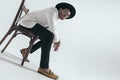 sexy young man holding elbows on knees and sitting on wooden chair