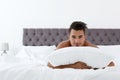 young man with soft pillow on bed Royalty Free Stock Photo