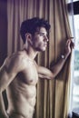 young man standing shirtless by curtains Royalty Free Stock Photo