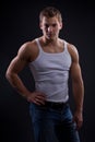 young man wearing white undershirt and jeans, posing over d Royalty Free Stock Photo