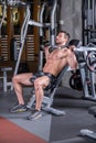 Sexy young muscular man doing upper chest exercise on the machine