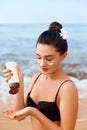 Sexy Young Woman in Bikini  Holding  Bottles of Sunscreen in Her Hands. Skin care. A Female  Applying Sun Cream Creme Royalty Free Stock Photo