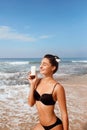 Sexy Young Woman in Bikini  Holding  Bottles of Sunscreen in Her Hands. Skin care. Royalty Free Stock Photo