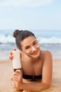 Sexy Young Woman in Bikini Holding Bottles of Sunscreen in Her Hands. Skincare. A Beautiful Female Applying Sun Cream. Royalty Free Stock Photo