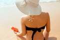 Sexy Young Woman in Bikini Holding Bottles of Sunscreen in Her Hands. Skincare. A Beautiful Female Applying Sun Cream. Royalty Free Stock Photo